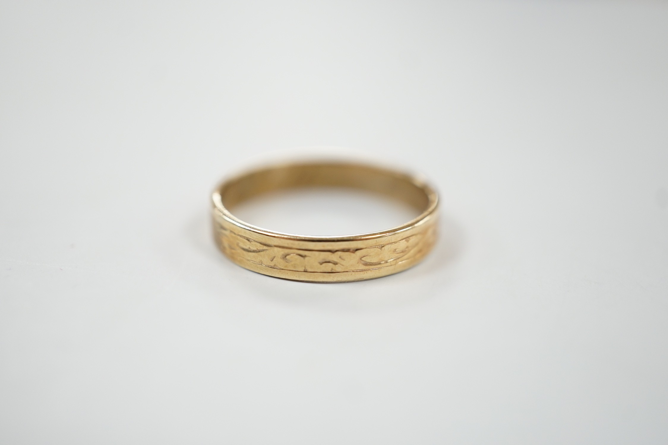 An engraved 9ct gold wedding band, size P, 2.1 grams.